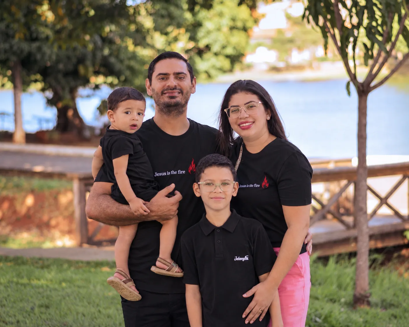 A família missionária reunida ao ar livre: o pai segurando o filho mais novo, a mãe e o filho mais velho